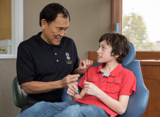 Dr. Ligh showing a child how to floss