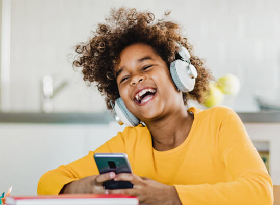 Child listening to headphones and laughing - great kids dentist San Jose, CA